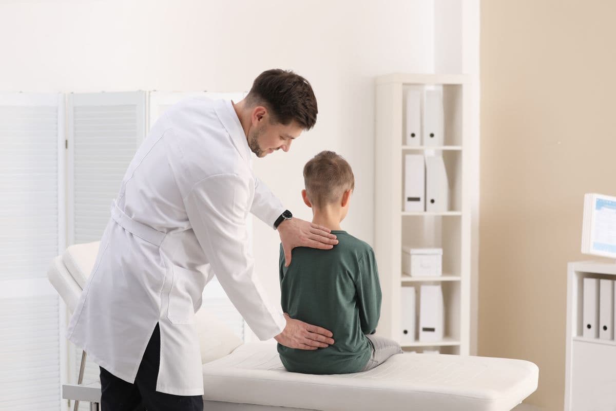 Chiropractor examining a child patient in clinic